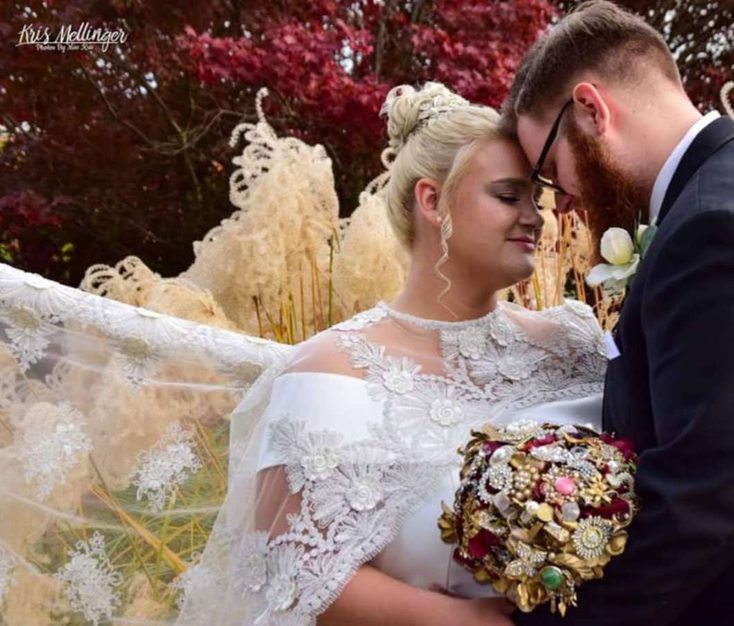 Bride and groom close up with lace veil and brooch bouquet